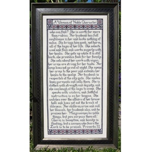 May include: A framed cross-stitch embroidery with a white background and black text. The text reads "A Woman of Noble Character who can find? She is worth far more than rubies. Her husband has full confidence in her and lacks nothing of value. She brings him good, not harm, all of the days of her life. She selects wool and flax and works eagerly with her hands. She gets up while it is still dark, she provides food for her family. She sets about her work with vigor, her arms are strong for her tasks. Her lamp does not go out at night. She opens her arms to the poor and extends her hands to the needy. Her husband is respected at the city gate. She makes linen garments and sells them. She is clothed with strength and dignity, and she can laugh at the days to come. She speaks with wisdom, and faithful instruction is on her tongue. She watches over the affairs of her house-hold and does not eat the bread of idleness. Her children arise and call her blessed, her husband also, and he praises her: Many women do noble things, but you surpass them all. Charm is deceptive, and beauty is fleeting, but a woman who fears the Lord is to be praised. Proverbs 31"