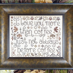Pode incluir: Um bordado de ponto cruz enquadrado com fundo castanho e texto branco que diz "Eu te amo mais do que café, só que nem sempre antes do café".