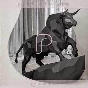 May include: A black geometric paper sculpture of a bull, standing on a rock-like base. The sculpture has sharp angles and a modern design. The image includes the text "SVG | DXF | EPS | PDF TEMPLATE" at the top.