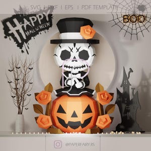 Könnte beinhalten: Eine Halloween-Papierbastel-Szene mit einem Skelett mit Zylinder und Fliege, das auf einem geschnitzten Kürbis sitzt. Die Dekoration umfasst orangefarbene Rosen, eine Geisterhaus-Silhouette und den Schriftzug "Happy Halloween."