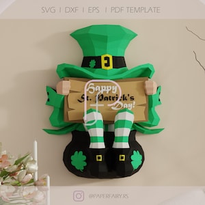 Puede incluir: Decoración de papel para el Día de San Patricio con un sombrero verde con una banda negra y hebilla dorada, y una olla de oro. El letrero dice "Happy St. Patrick's Day!". Las piernas del duende son a rayas verdes y blancas.