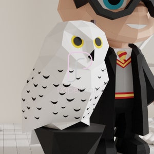 Close-up of a low poly papercraft snowy owl with yellow eyes and black feather markings, standing next to the wizard figure. Part of a printable DIY papercraft template with digital files for easy crafting.