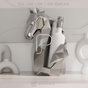 Könnte beinhalten: Ein silberner, geometrischer Pferdekopf-Weinflaschenhalter mit einer weißen Weinflasche. Der Halter hat ein modernes, eckiges Design. Das Bild enthält den Text "SVG | DXF | EPS | PDF TEMPLATE" und den Instagram-Handle "@PAPERFAIRY.RS".