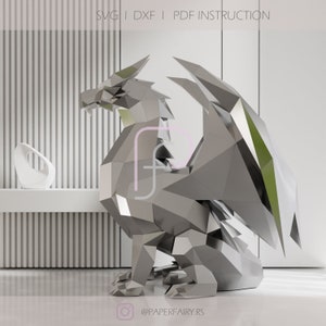 May include: A silver and green origami dragon sculpture. The dragon is sitting on its hind legs with its wings spread out. The sculpture is made of paper and is very detailed.