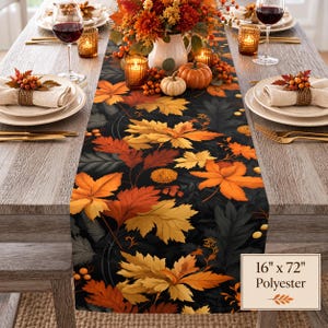 May include: A table runner featuring a dark background with a vibrant pattern of orange, yellow, and red autumn leaves, small berries, and flowers. The runner is made of polyester and measures 16 inches by 72 inches as indicated by the text label.