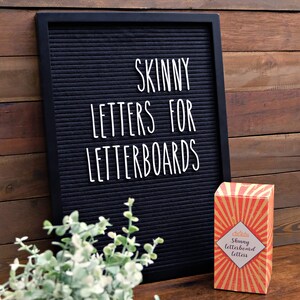 May include: A black letter board with the text "SKINNY LETTERS FOR LETTERBOARDS" in white letters. A box of letterboard letters with a red, yellow, and gold design is in the foreground. The box has the text "Skinny letterboard letters" in white letters.