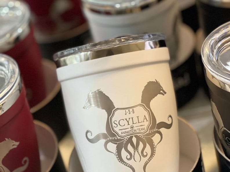 White stainless steel tumbler with silver SCYLLA ANIMATION TEAM logo, featuring a mythical creature and octopus tentacles. Perfect for coffee, tea, or any beverage. Ideal gift for animation fans.