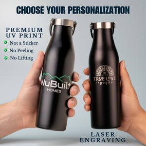 Puede incluir: Dos botellas de agua de metal negro mate con tapas plateadas. La botella izquierda presenta un logotipo verde de NuBuilt Homes con el texto Premium UV Print, Not a Sticker, No Peeling, No Lifting. La derecha muestra un logo grabado True Love Yoga.