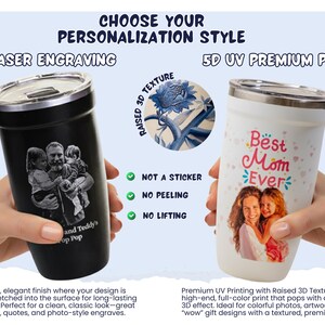 A person's hands holding two personalized tumblers, one with a black engraved design and the other with a colorful design featuring a family portrait.