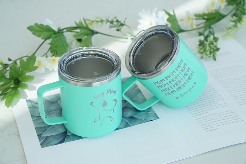 Mint green stainless steel tumblers for dog moms. Features Dog Mom and Mom Mom Mom text with a dog silhouette. Perfect gift for dog lovers, a cute way to enjoy drinks on the go.