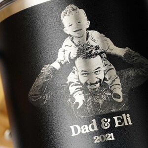 Personalized black tumbler featuring a laser-engraved photo of a father and child, with Dad & Eli 2021 text. Ideal custom gift for dads, Father's Day, or birthdays.