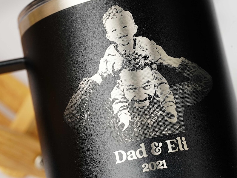 Personalized black tumbler featuring a laser-engraved photo of a father and child, with Dad & Eli 2021 text. Ideal custom gift for dads, Father's Day, or birthdays.