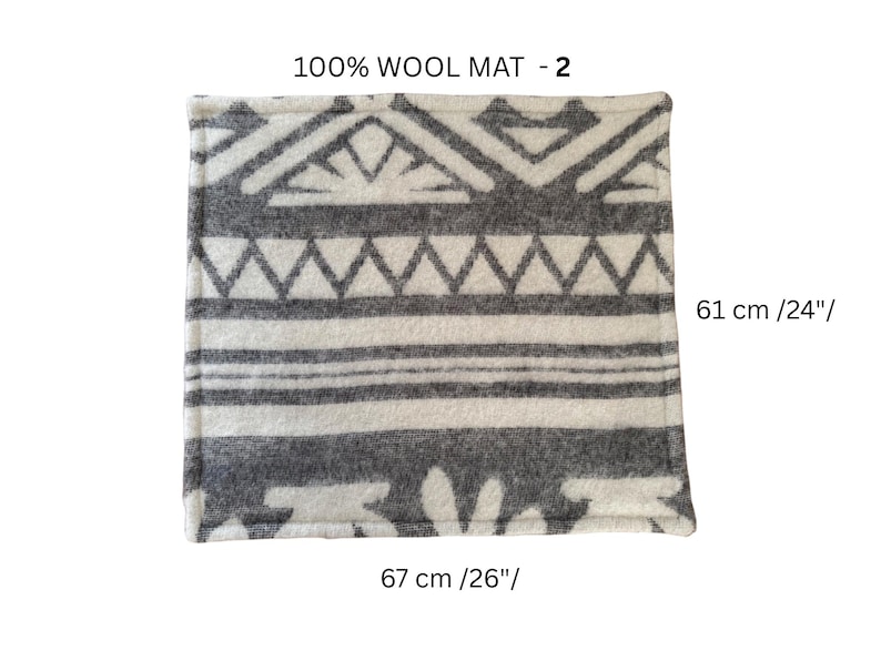 K&ouml;nnte beinhalten: Ein quadratischer Wollteppich mit einem geometrischen Muster in Grau und Wei&szlig;. Der Teppich ist 67 cm lang und 61 cm breit. Der Text "100% WOOL MAT - 2" ist oben aufgedruckt.