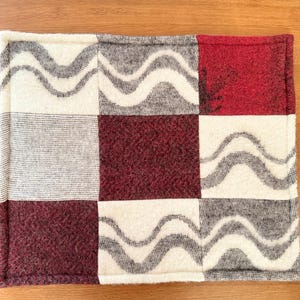 Side profile view of the hem of the wool pet mat, showing the thickness and finished edge.