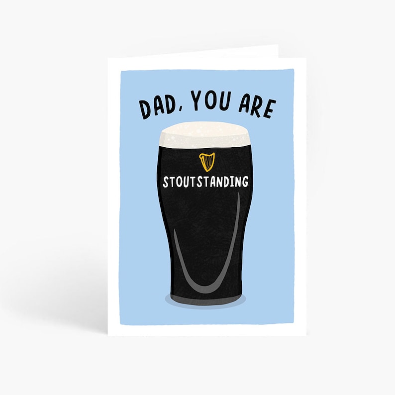 Op de afbeelding: Wenskaart met een lichtblauwe achtergrond en een pint stout. De tekst "DAD, YOU ARE STOUTSTANDING" staat op de kaart. De pint stout heeft een witte schuimkraag en het Guinness-logo.
