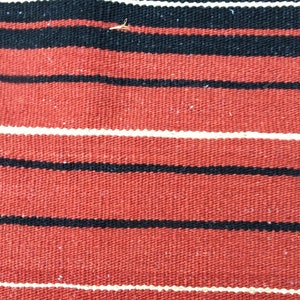 Pu&ograve; includere: Tessuto rosso con strisce bianche e nere. Il tessuto ha una trama tessuta.
