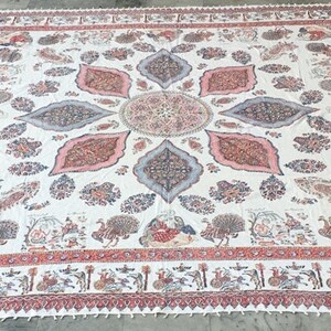 Könnte beinhalten: Ein weißer Baumwoll-Teppich mit einem roten und rosafarbenen Blumenmuster. Der Teppich hat ein zentrales Medaillon mit einem sich wiederholenden Muster aus Blättern und Blumen. Der Teppich ist von einem Rand mit einem sich wiederholenden Muster aus kleinen Blumen und Blättern umgeben.