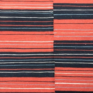 Pu&ograve; includere: Tessuto tessuto a righe rosse, nere e bianche. Il tessuto presenta un motivo orizzontale con righe alternate di rosso, nero e bianco.