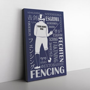 Puede incluir: Una impresión en lienzo azul con una silueta blanca de un esgrimista sosteniendo un florete. La palabra "Fencing" está escrita en letras blancas grandes en la parte inferior de la impresión. Las palabras "击剑", "ESGRIMA", "SCHERMA", "펜싱", "ESKRIM", "SCRIMA", "FECHTEN", "FAKTNING", "ESCRIME", "ФЕХТОВАНИЕ", "VEHKLEMINE", "SZERMIERKA", "SCHERMEN", "MIEKKAILU" y "VÍVÁS" están escritas alrededor del esgrimista en un círculo.