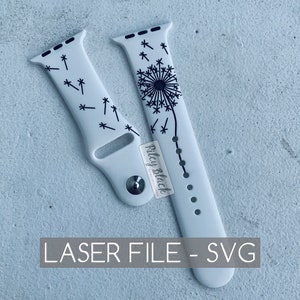 May include: White Apple Watch band with a black dandelion design. The band is made of silicone and has a laser-cut design. The band is for a 40mm or 44mm Apple Watch.