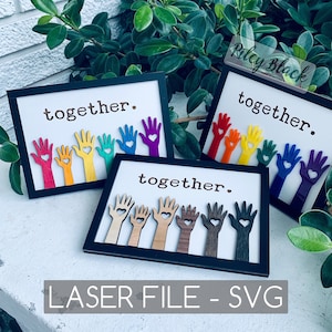May include: Three framed art pieces with the word "together" and colorful hand cutouts. The hands are various colors, including red, orange, yellow, green, blue, and purple. The bottom of the image reads "LASER FILE - SVG".