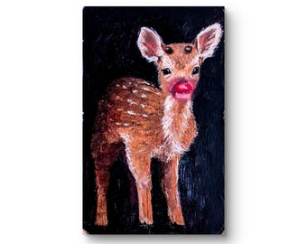 Puede incluir: Pintura al óleo de un ciervo sobre un fondo negro. El ciervo es marrón con manchas blancas y orejas grandes. El ciervo tiene labios rojos. La pintura está sobre un lienzo rectangular.