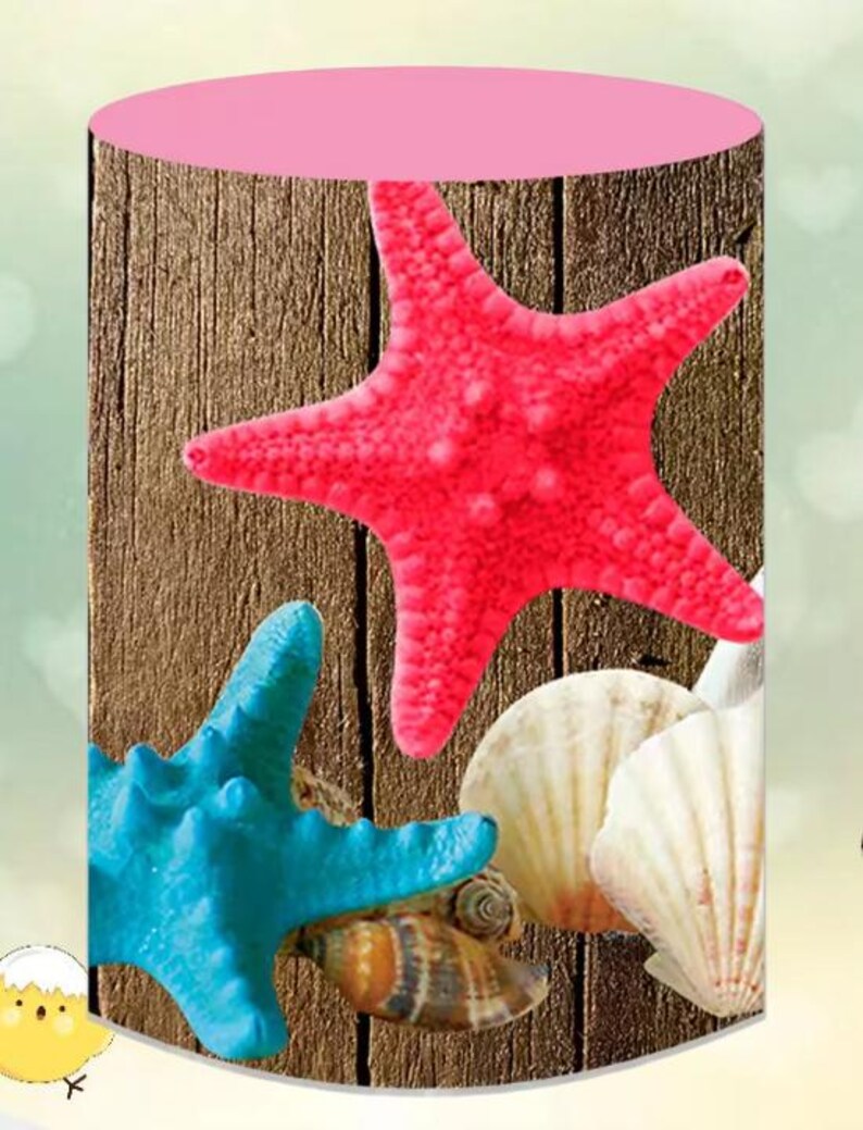 Puede incluir: Un mantel redondo rosa con un patr&oacute;n de veta de madera que presenta una estrella de mar rosa, una estrella de mar azul y conchas.