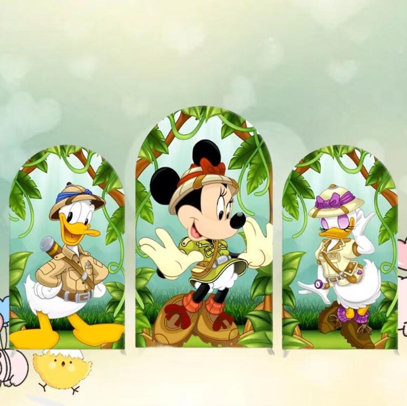 Puede incluir: Tres personajes de Disney con trajes de safari: Pato Donald, Minnie Mouse y Pata Daisy. Cada personaje est&aacute; enmarcado por un arco verde con enredaderas de la jungla. Pato Donald sostiene unos prism&aacute;ticos, Minnie Mouse tiene un lazo rojo y Pata Daisy lleva un sombrero morado.