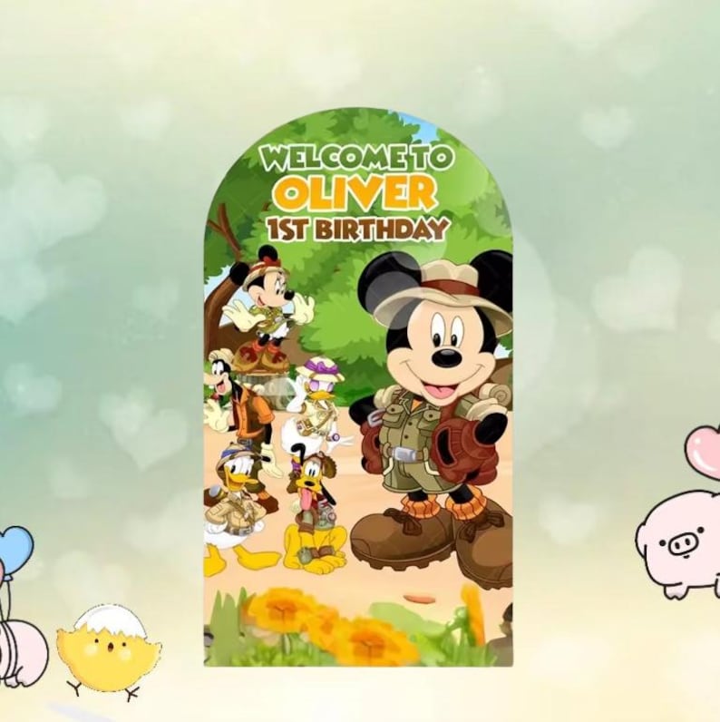 以下が含まれることがあります： ミッキーマウスがサファリ風の衣装を着て、他のディズニーキャラクターに囲まれた、カラフルな誕生日をテーマにしたグラフィック。 「WELCOME TO OLIVER 1ST BIRTHAY」の文字がキャラクターの上に、緑色の背景に表示されています。