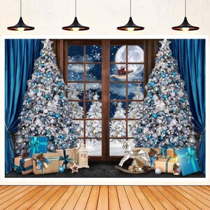 Könnte beinhalten: Ein Weihnachtshintergrund mit zwei geschmückten Weihnachtsbäumen mit blauen und silbernen Ornamenten, einem Fenster mit einer verschneiten Waldszene und einem Schaukelpferd. Der Hintergrund ist perfekt für Weihnachtsfotoshootings.