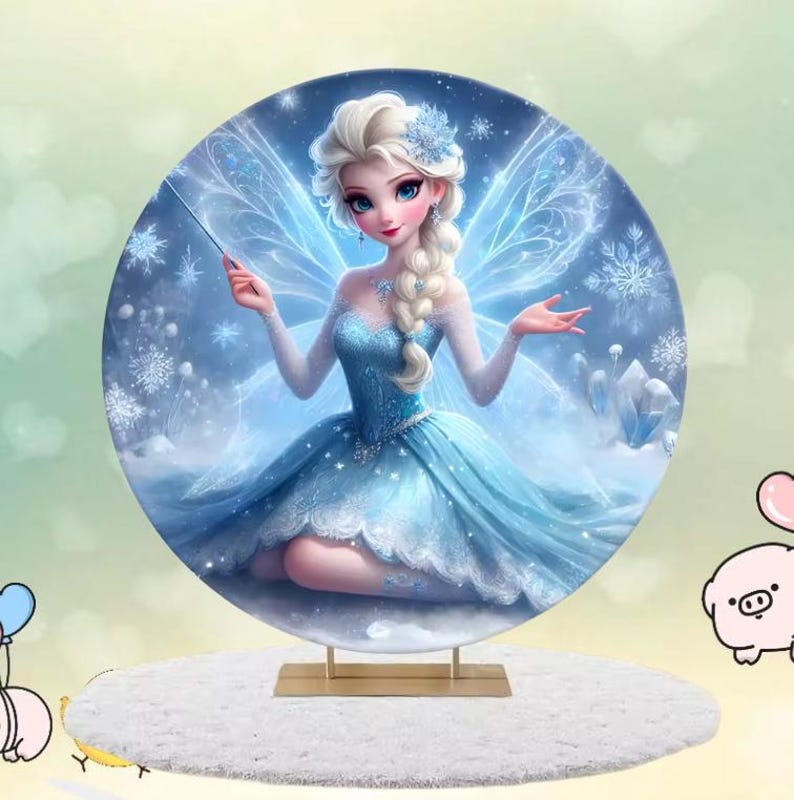 May include: A round backdrop featuring a blue and white fairy with a wand, snowflakes, and ice crystals. The fairy is wearing a blue dress with a white lace trim and has long blonde hair. The backdrop is perfect for a winter wonderland themed party.
