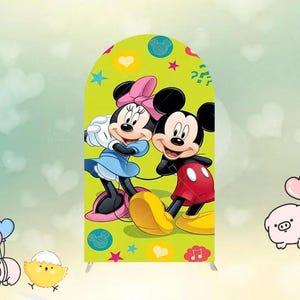 May include: A green backdrop featuring Mickey and Minnie Mouse. Minnie wears a pink bow and blue dress, while Mickey sports red shorts. The backdrop is decorated with hearts, stars, and musical notes, creating a cheerful, cartoon-themed design.