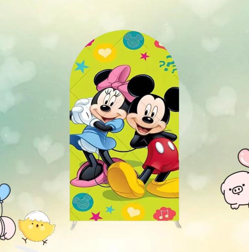 May include: A green arch-shaped backdrop featuring Mickey and Minnie Mouse. Mickey wears red shorts and yellow shoes, while Minnie wears a blue dress and pink bow. The backdrop has hearts, stars, and musical notes.
