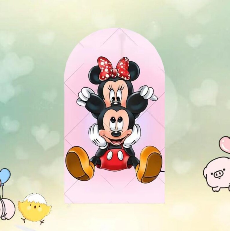 May include: A pink beanie featuring a cartoon illustration of Mickey and Minnie Mouse. Minnie Mouse is wearing a red bow with white polka dots. Mickey Mouse is wearing red shorts and yellow shoes. The background is a light pink color.