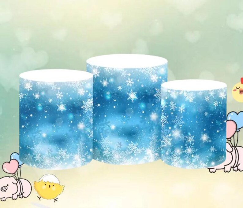 May include: Three round cake stands with a blue and white snowflake pattern. The stands are different sizes and are stacked on top of each other.