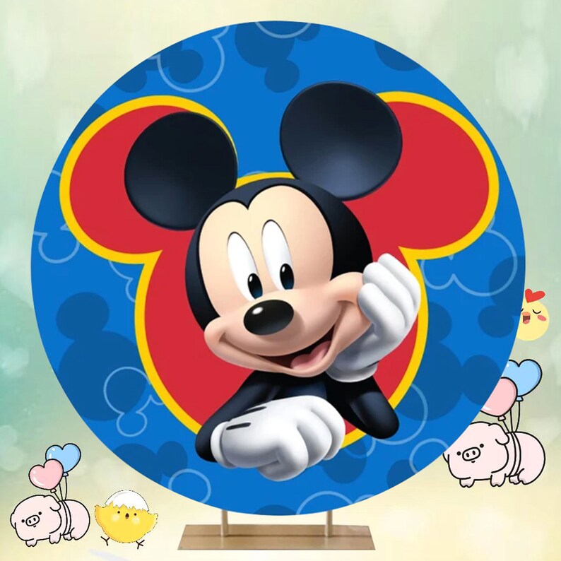 May include: A round blue and red backdrop featuring a cartoon image of Mickey Mouse. Mickey Mouse is smiling and has his hand on his chin. The backdrop is ideal for a birthday party or other celebration.