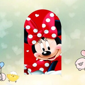 May include: A cartoon illustration of Minnie Mouse, featuring a red dress with white polka dots and a matching bow. The background is a light green with white heart shapes. Minnie Mouse is smiling.
