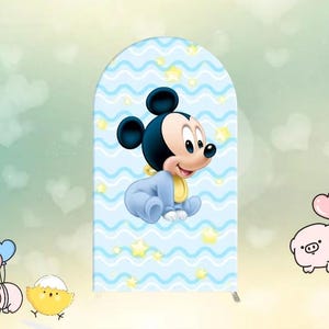 May include: A blue and white baby shower backdrop with a cartoon baby Mickey Mouse wearing a blue onesie and a yellow bib. The backdrop has a wavy pattern with white stars.