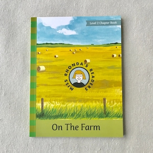 May include: A green and yellow book cover with a picture of a field of hay bales. The book title is "On The Farm" and the book is part of the "Miss Rhonda's Readers" series. The book is labeled as a Level 2 Chapter Book.
