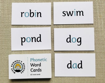 May include: Set of 5 white flash cards with black text and blue circles. The words on the cards are "robin", "swim", "pond", "dog", and "dad". The cards are part of a set of 62 phonetic word cards.