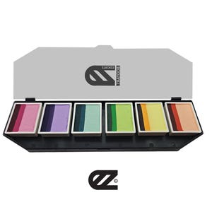 Puede incluir: Una paleta de seis pinturas faciales en una caja de plástico negro. Los colores son rosa, morado, verde azulado, verde, amarillo y melocotón. La paleta está etiquetada como "BodyArtz".