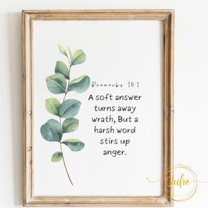 May include: A framed print with a watercolor illustration of a eucalyptus branch. The print features the Bible verse Proverbs 15:1, which reads "A soft answer turns away wrath, But a harsh word stirs up anger."