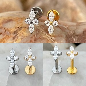 May include: Four different styles of clear crystal flower shaped body jewellery. The jewellery is made of surgical steel and comes in gold and silver.