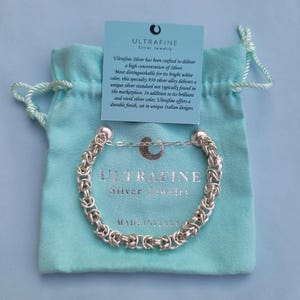 K&ouml;nnte beinhalten: Ein silbernes Armband mit einem Kettenglieddesign. Das Armband ist in Italien hergestellt und tr&auml;gt die Aufschrift "Ultrafine Silver Jewelry".