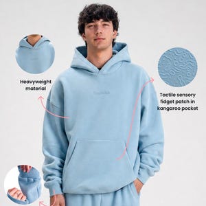 Peut inclure: Un sweat à capuche bleu clair en matière épaisse avec une poche kangourou dotée d'un patch sensoriel tactile, une balle anti-stress intégrée dans le poignet et le texte CouchClub brodé sur la poitrine et le pantalon assorti.