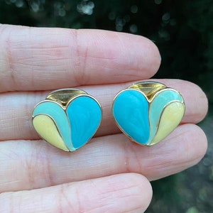Puede incluir: Un par de pendientes de corazón de oro con esmalte azul, verde y amarillo.