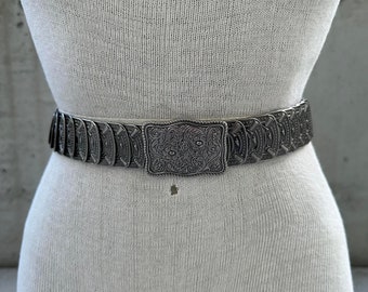 80s silver tone elastic belt, vintage metal plaque scale waistband, floral buckle, maximalist southwestern fashion, medieval princess style