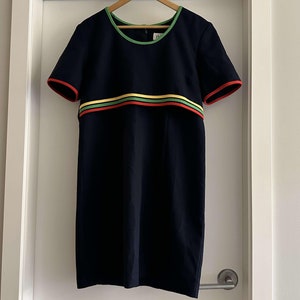 May include: A navy blue dress with short sleeves and a colorful stripe across the chest. The stripe is yellow, green, and red.