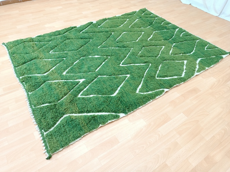 May include: Green and white area rug with a diamond pattern. The rug has a fluffy texture.