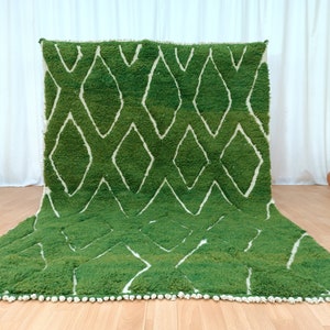 May include: A green and white Moroccan rug with a diamond pattern. The rug has a fringe border.